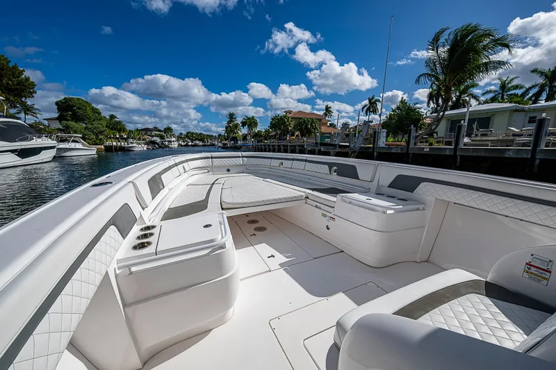  Yacht Photos Pics 2019 Intrepid 407 Nomad FE boat interior with luxurious seating, docked under a clear blue sky.