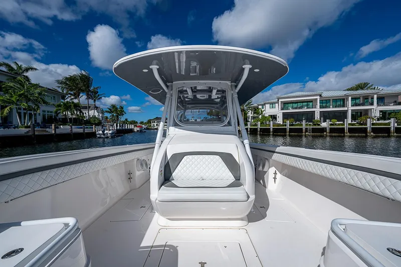  Yacht Photos Pics 2019 Intrepid 407 Nomad FE boat with sleek design, docked near waterfront homes.