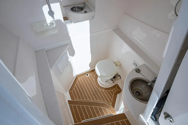  Yacht Photos Pics 2019 Intrepid 407 Nomad FE boat bathroom with toilet, sink, and wooden floor.