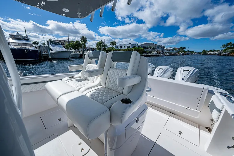  Yacht Photos Pics Luxurious seating on a 2019 Intrepid 407 Nomad FE boat, docked by waterfront homes.