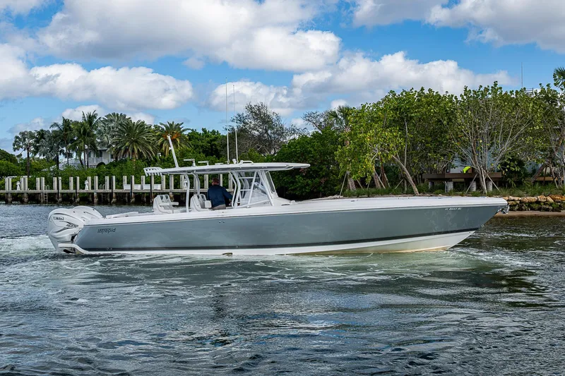  Yacht Photos Pics 2019 Intrepid 407 Nomad FE boat cruising on a scenic waterway with lush greenery.