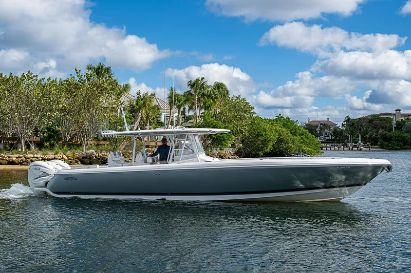  Yacht Photos Pics 2019 Intrepid 407 Nomad FE boat cruising on a scenic waterway with lush greenery.