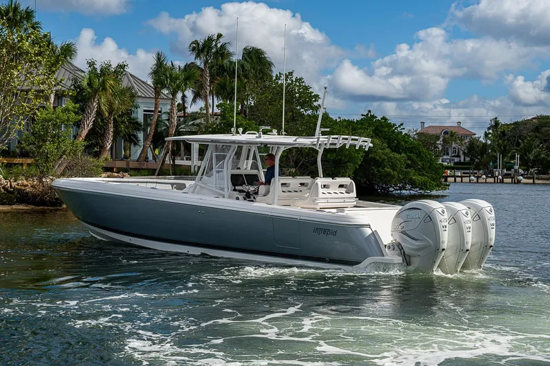  Yacht Photos Pics 2019 Intrepid 407 Nomad FE boat cruising on a sunny day near lush greenery.