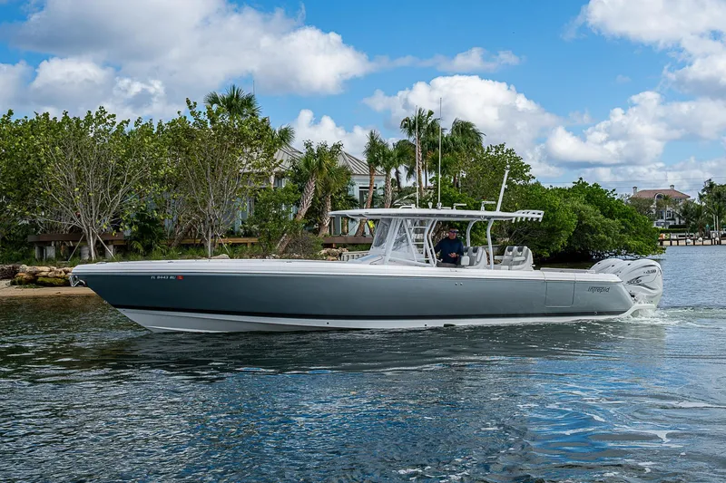  Yacht Photos Pics 2019 Intrepid 407 Nomad FE boat cruising on a sunny day near lush shoreline.