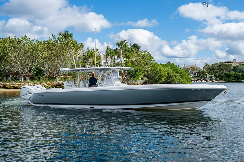  Yacht Photos Pics 2019 Intrepid 407 Nomad FE boat cruising on a sunny day near lush greenery.