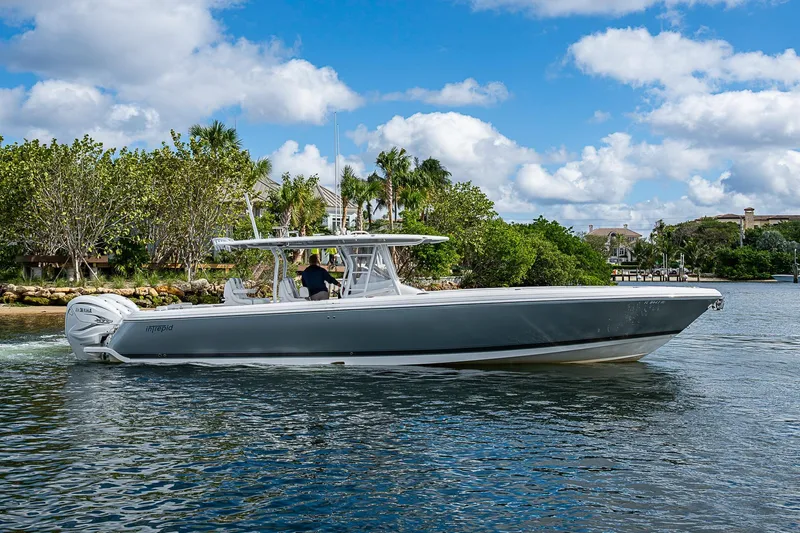  Yacht Photos Pics 2019 Intrepid 407 Nomad FE boat cruising on a sunny day, surrounded by lush greenery.