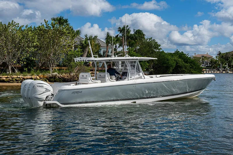  Yacht Photos Pics 2019 Intrepid 407 Nomad FE boat cruising on a sunny day with lush greenery background.