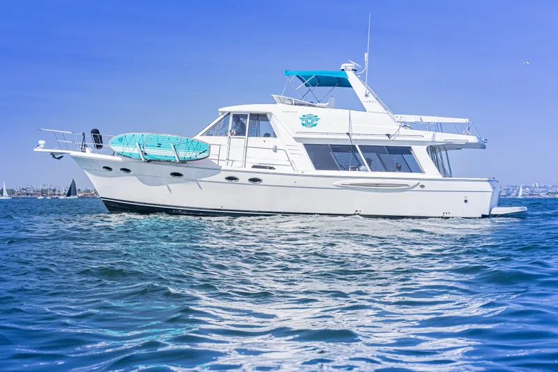 Adventures Await Yacht Photos Pics 2004 Meridian 490 Pilothouse yacht cruising on clear blue waters.