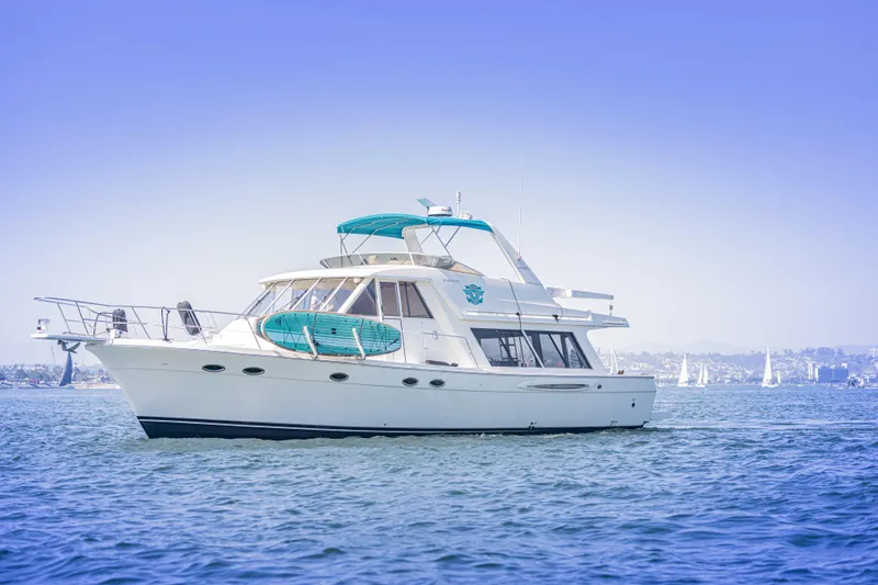 Adventures Await Yacht Photos Pics 2004 Meridian 490 Pilothouse yacht cruising on calm blue waters.