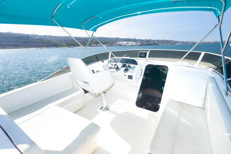 Adventures Await Yacht Photos Pics 2004 Meridian 490 Pilothouse boat interior with blue canopy on open water.