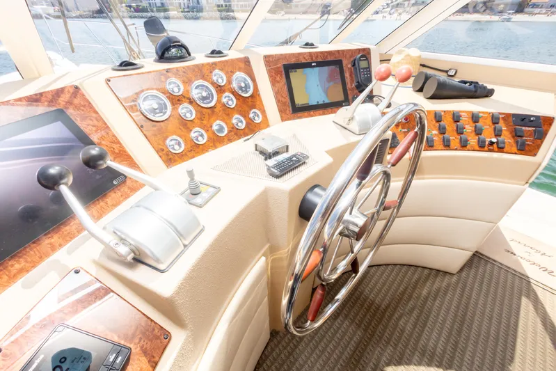 Adventures Await Yacht Photos Pics Pilothouse of 2004 Meridian 490, featuring steering wheel, controls, and navigation instruments.