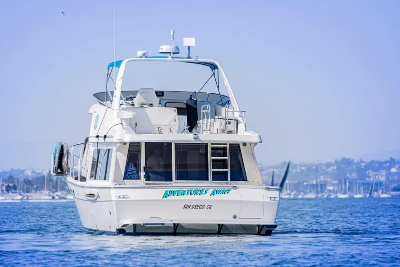 Adventures Await Yacht Photos Pics 2004 Meridian 490 Pilothouse yacht on water, San Diego backdrop.