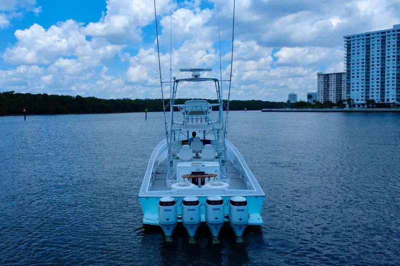 Highly Migratory Yacht Photos Pics 2017 Chesapeake 53 Center Console boat on calm water, cityscape in background.