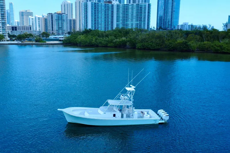 Highly Migratory Yacht Photos Pics 2017 Chesapeake 53 Center Console boat on calm water with city skyline backdrop.