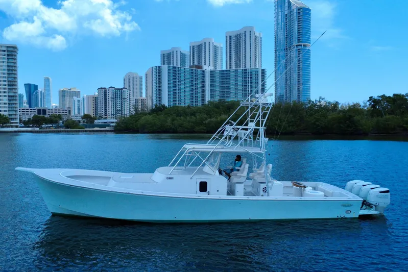 Highly Migratory Yacht Photos Pics 2017 Chesapeake 53 Center Console boat on water with city skyline background.
