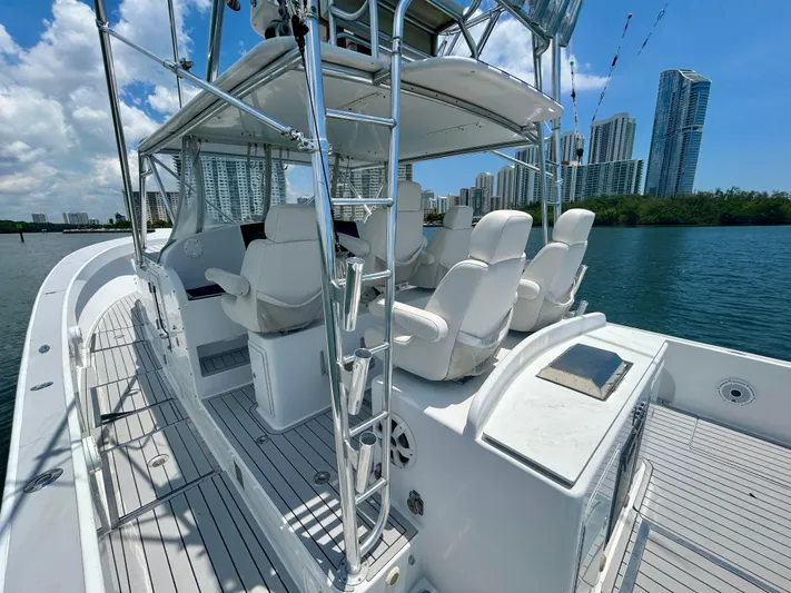 Highly Migratory Yacht Photos Pics 2017 Chesapeake 53 Center Console boat with white seating, city skyline in background.