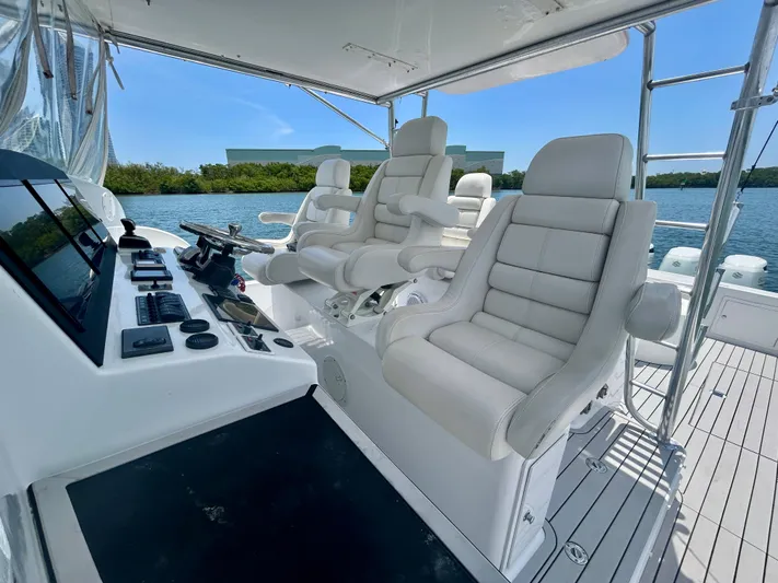 Highly Migratory Yacht Photos Pics 2017 Chesapeake 53 Center Console interior with luxurious white seating and advanced control panel.