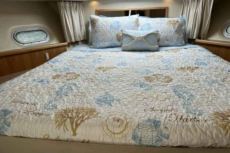  Yacht Photos Pics Luxurious bedroom interior of 2000 Bayliner 5288 Pilot House Motoryacht with nautical-themed bedding.