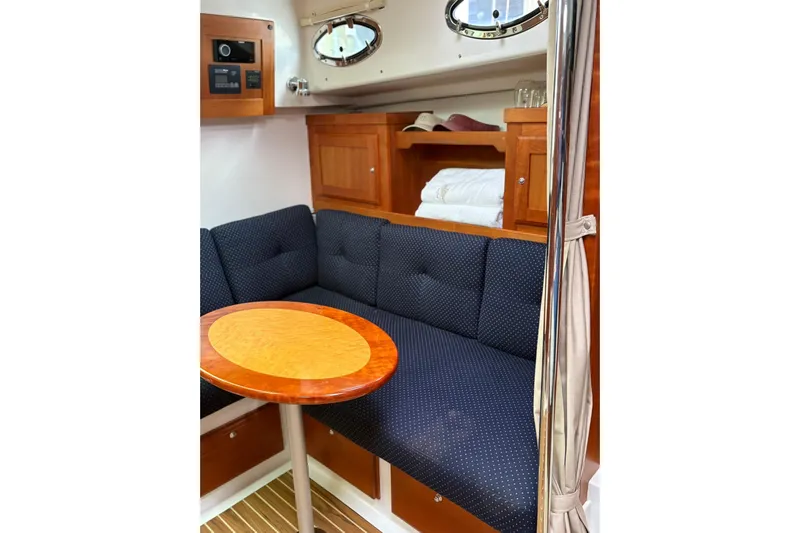  Yacht Photos Pics Cozy interior of 2013 Back Cove 34 yacht with cushioned seating and wooden table.