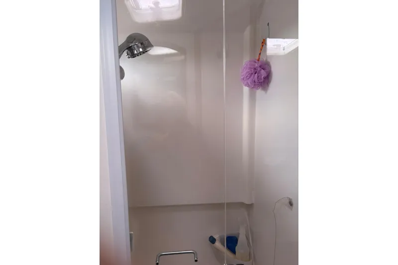  Yacht Photos Pics Shower area inside 2013 Back Cove 34 boat, featuring a showerhead and purple loofah.