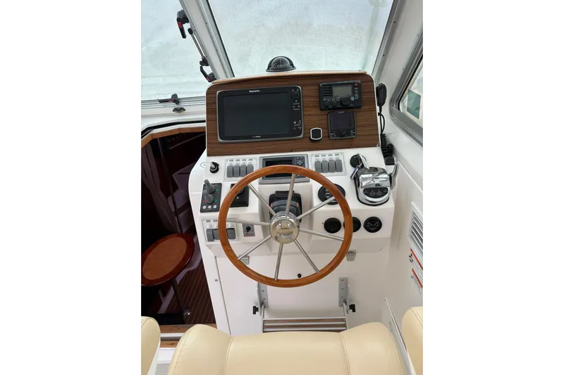  Yacht Photos Pics 2013 Back Cove 34 helm with wooden steering wheel and modern navigation equipment.