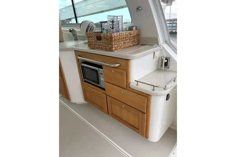  Yacht Photos Pics 2013 Back Cove 34 yacht interior kitchen with microwave, wooden cabinets, and countertop basket.