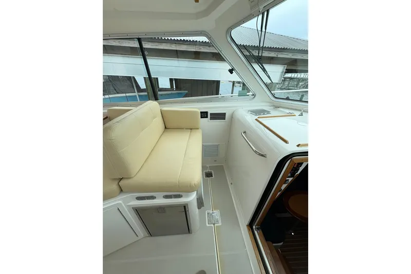  Yacht Photos Pics Interior view of 2013 Back Cove 34 boat with beige seating and large windows.