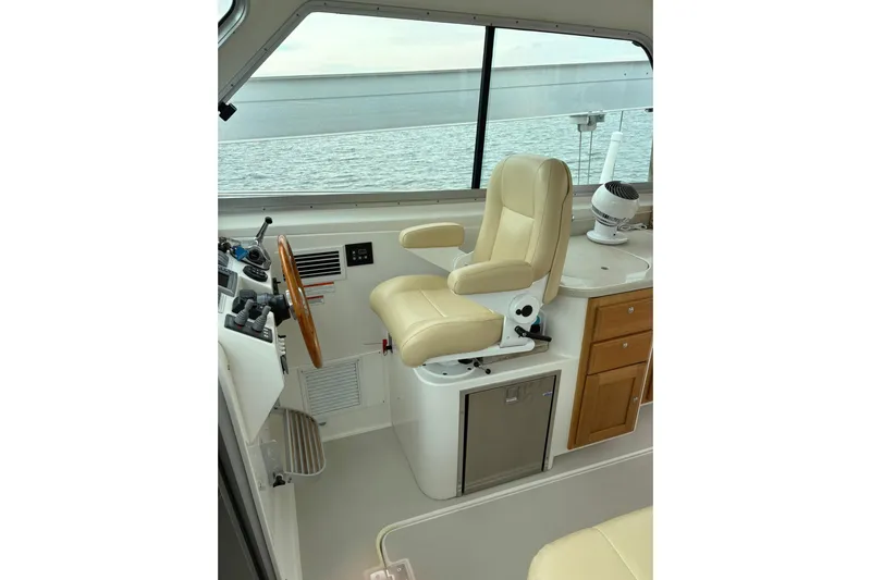  Yacht Photos Pics Helm station of 2013 Back Cove 34 boat with beige captain's chair and wooden accents.