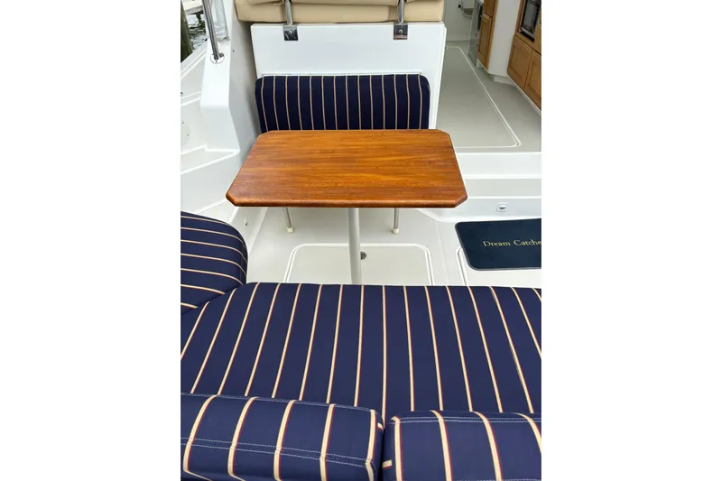  Yacht Photos Pics 2013 Back Cove 34 boat interior with striped seating and wooden table.