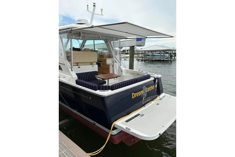  Yacht Photos Pics 2013 Back Cove 34 boat docked, featuring a spacious deck and striped seating.