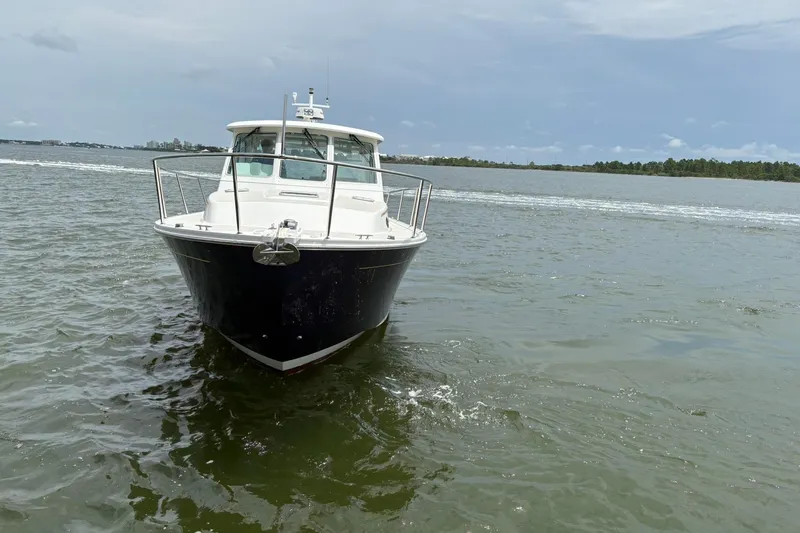  Yacht Photos Pics 2013 Back Cove 34 boat on calm water under a cloudy sky.