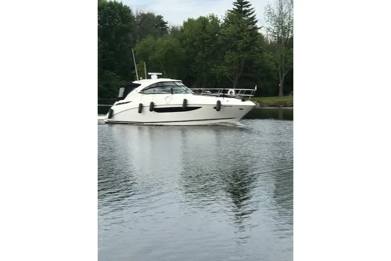  Yacht Photos Pics 2014 Sea Ray 410 Sundancer yacht cruising on a calm lake with lush greenery.