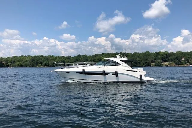  Yacht Photos Pics 2014 Sea Ray 410 Sundancer cruising on a lake under a partly cloudy sky.