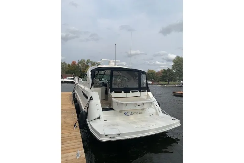  Yacht Photos Pics 2014 Sea Ray 410 Sundancer yacht docked on a calm lake under cloudy skies.