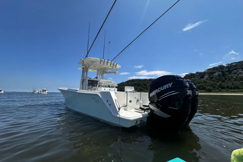 Engel-sea Yacht Photos Pics 2014 SeaVee 290B boat with twin Mercury engines on calm water, clear sky background.
