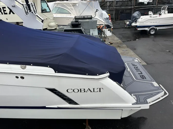  Yacht Photos Pics 2022 Cobalt R8 Surf boat with cover, docked in a marina.