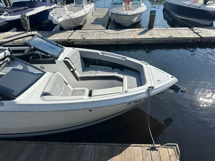  Yacht Photos Pics 2022 Cobalt R8 Surf boat docked at a marina, featuring sleek design and spacious seating.