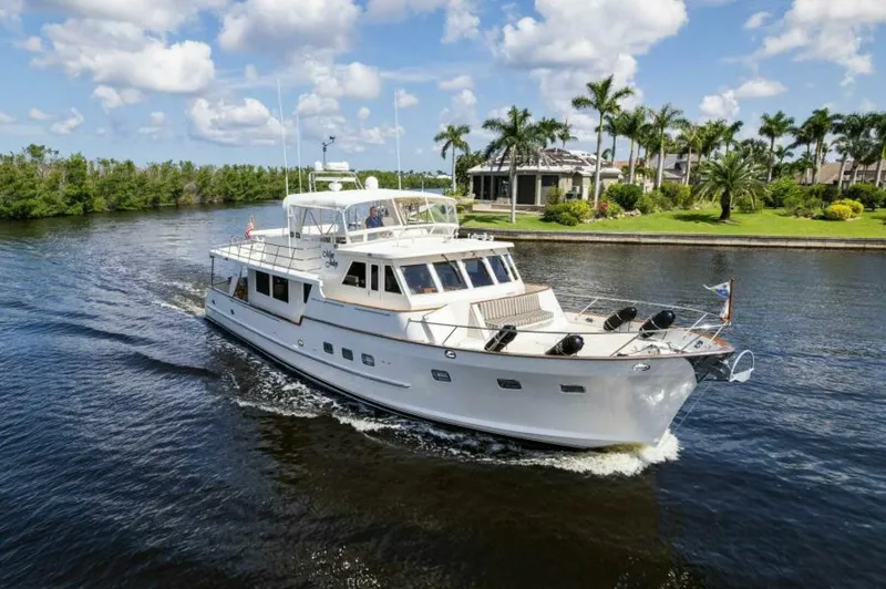 Orion II Yacht Photos Pics 2001 Grand Alaskan 64 Pilot House yacht cruising on a scenic waterway with palm trees.