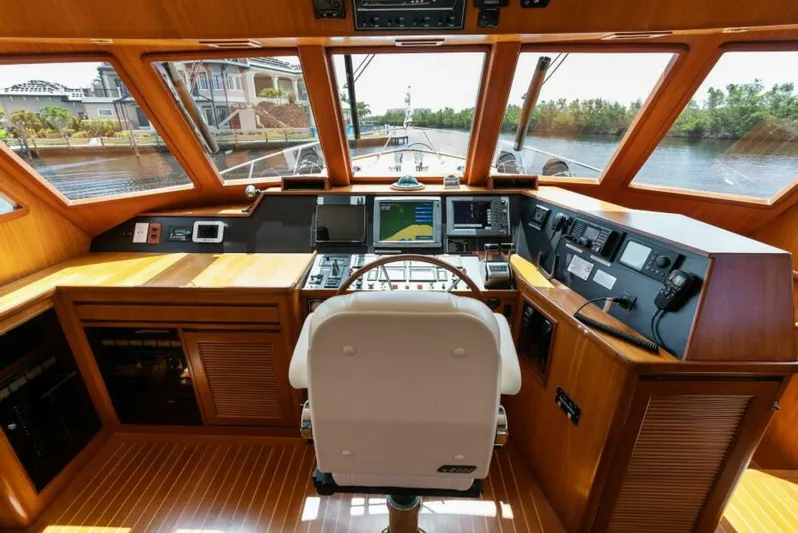 Orion II Yacht Photos Pics Pilot house interior of 2001 Grand Alaskan 64, featuring navigation equipment and wooden finishes.