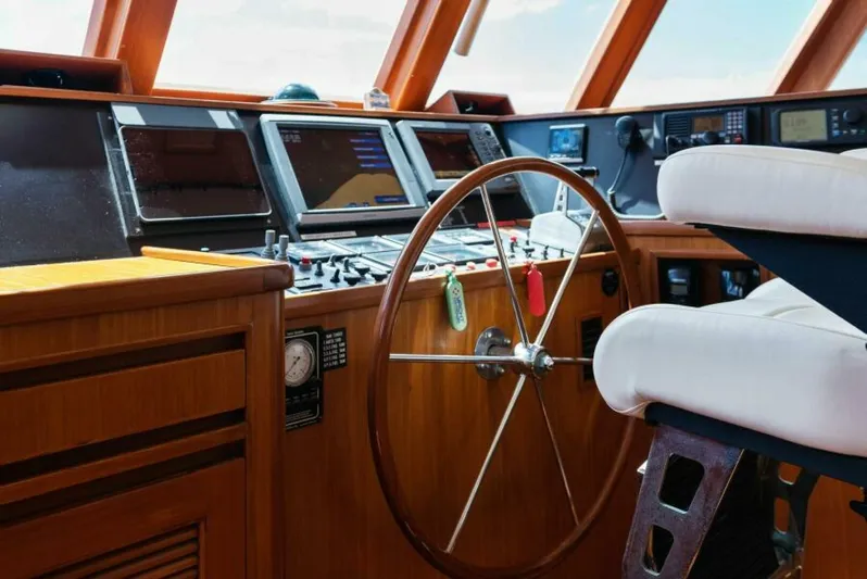 Orion II Yacht Photos Pics Pilot house interior of 2001 Grand Alaskan 64, featuring steering wheel and navigation equipment.