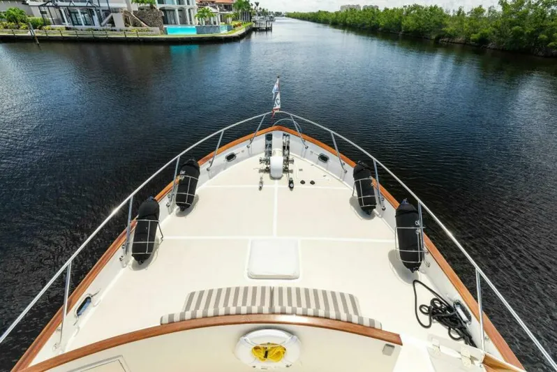 Orion II Yacht Photos Pics Bow view of 2001 Grand Alaskan 64 Pilot House yacht on a serene waterway.