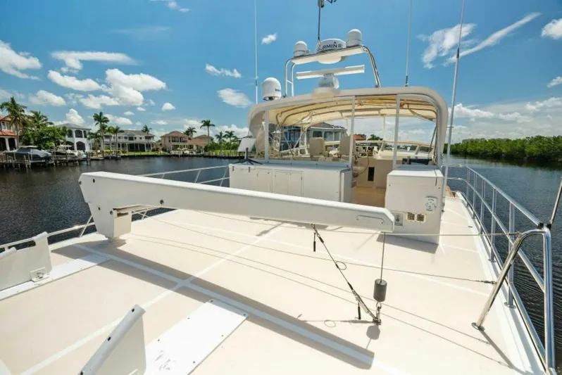 Orion II Yacht Photos Pics 2001 Grand Alaskan 64 Pilot House yacht on a sunny day, docked by waterfront homes.