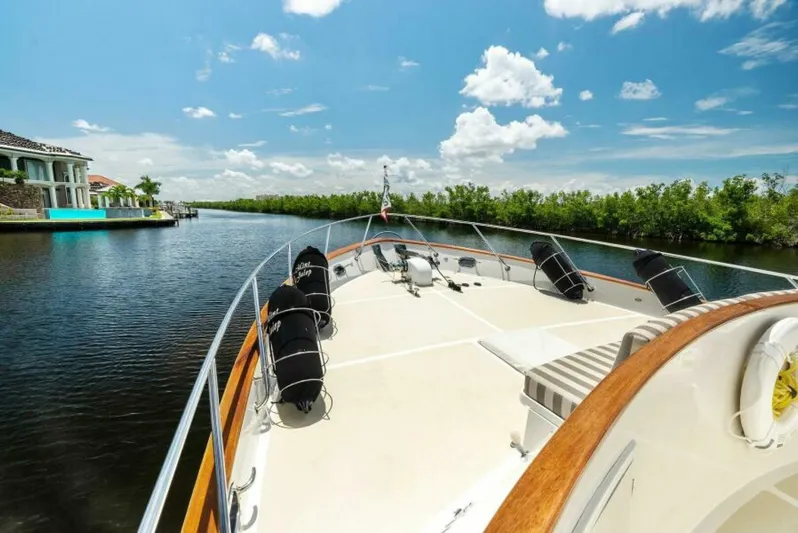 Orion II Yacht Photos Pics 2001 Grand Alaskan 64 Pilot House yacht cruising on a sunny day, scenic waterfront view.