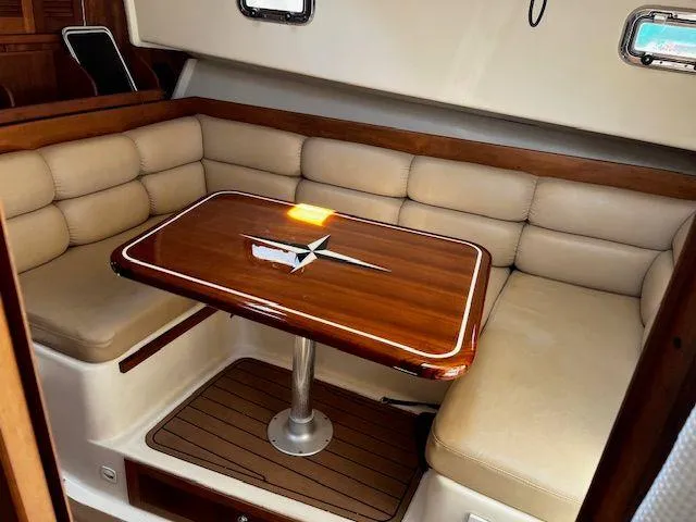  Yacht Photos Pics 2003 Mainship Pilot 34 interior with beige seating and wooden table.