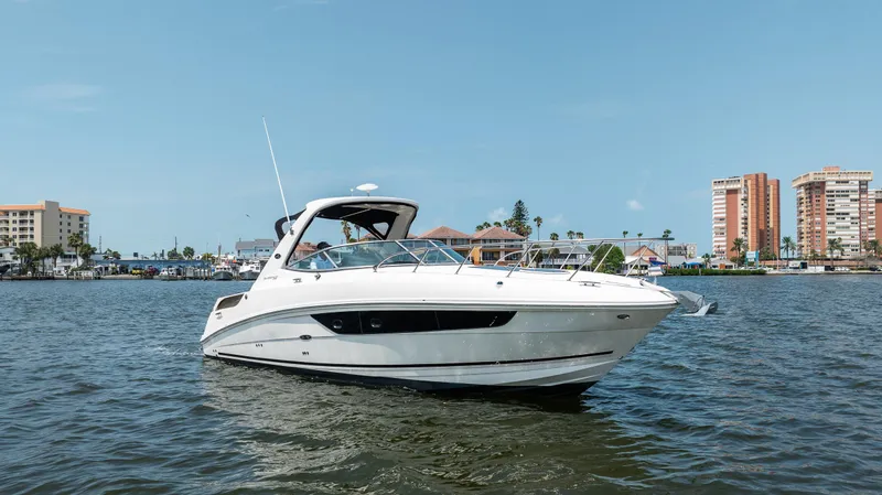  Yacht Photos Pics 2016 Sea Ray 310 Sundancer yacht on water with cityscape background.