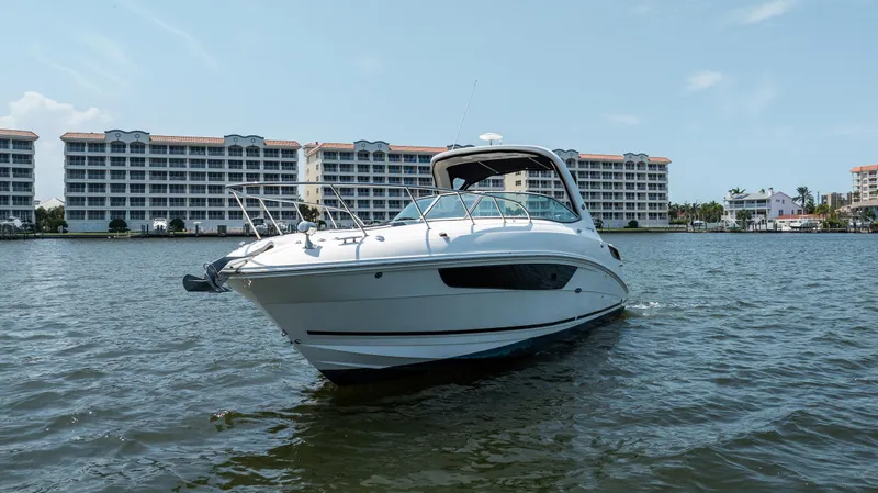 Yacht Photos Pics 2016 Sea Ray 310 Sundancer boat on water with buildings in background.