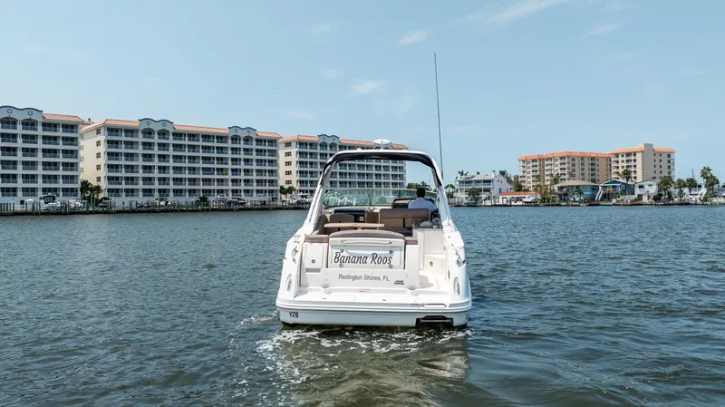  Yacht Photos Pics 2016 Sea Ray 310 Sundancer boat cruising near waterfront buildings.