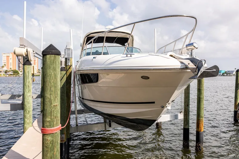  Yacht Photos Pics 2016 Sea Ray 310 Sundancer boat docked on a lift by the water.