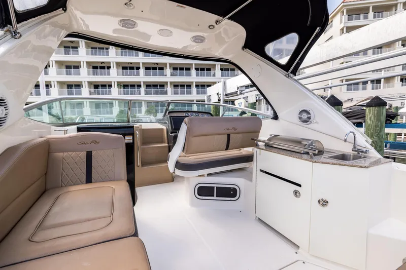  Yacht Photos Pics 2016 Sea Ray 310 Sundancer interior with seating, kitchenette, and helm, docked near buildings.