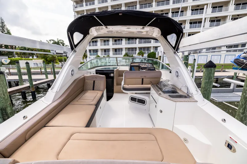  Yacht Photos Pics 2016 Sea Ray 310 Sundancer boat interior with seating and kitchenette at a marina.